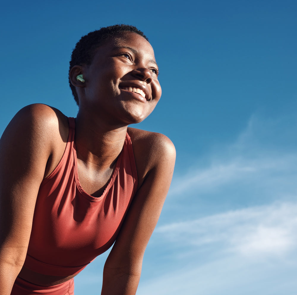 Woman smiling outside with blue sky behind her