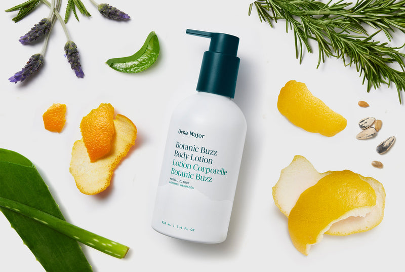 White Body Lotion bottle with green pump on a white background with lemon peels and lavender flowers.