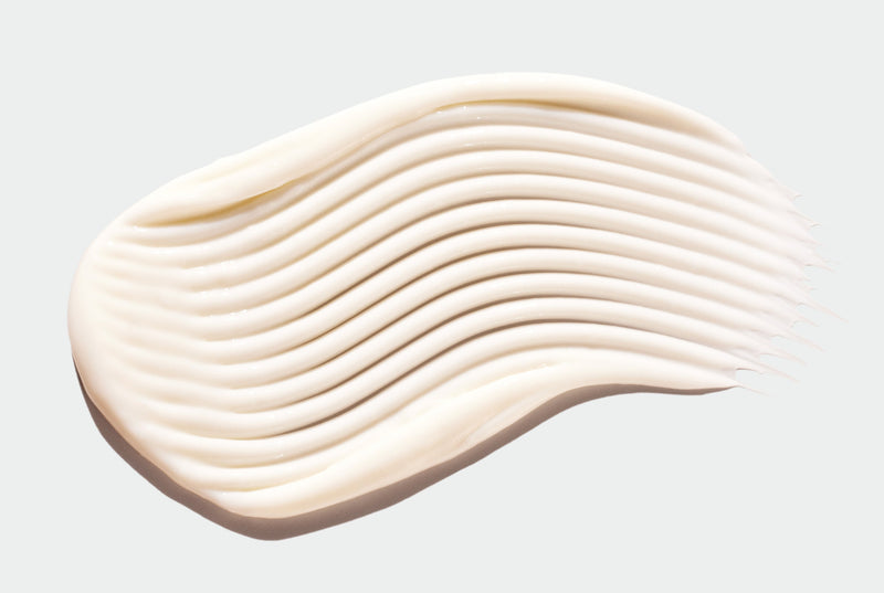 Smooth swirl of beige Body Lotion on a light gray background