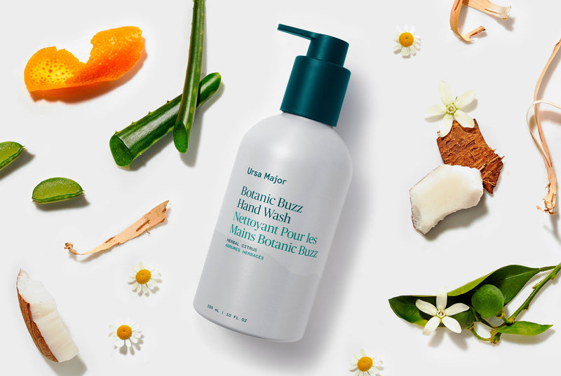 White bottle of hand wash with green pump on a white background with natural elements