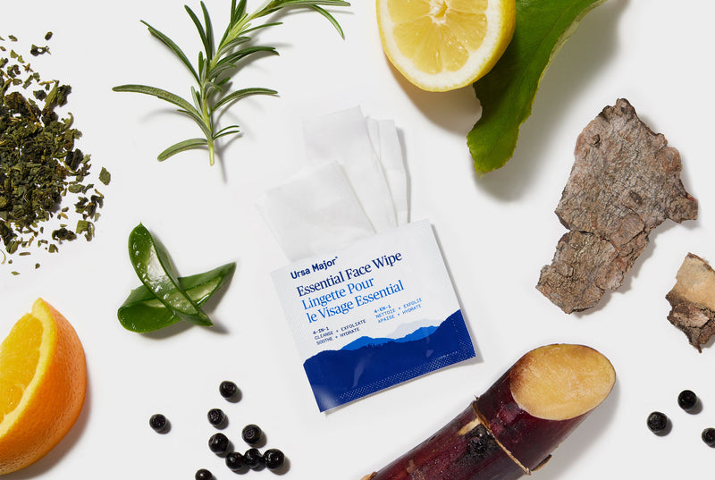 Ursa Major essential face wipe surrounded by natural ingredients on a white background