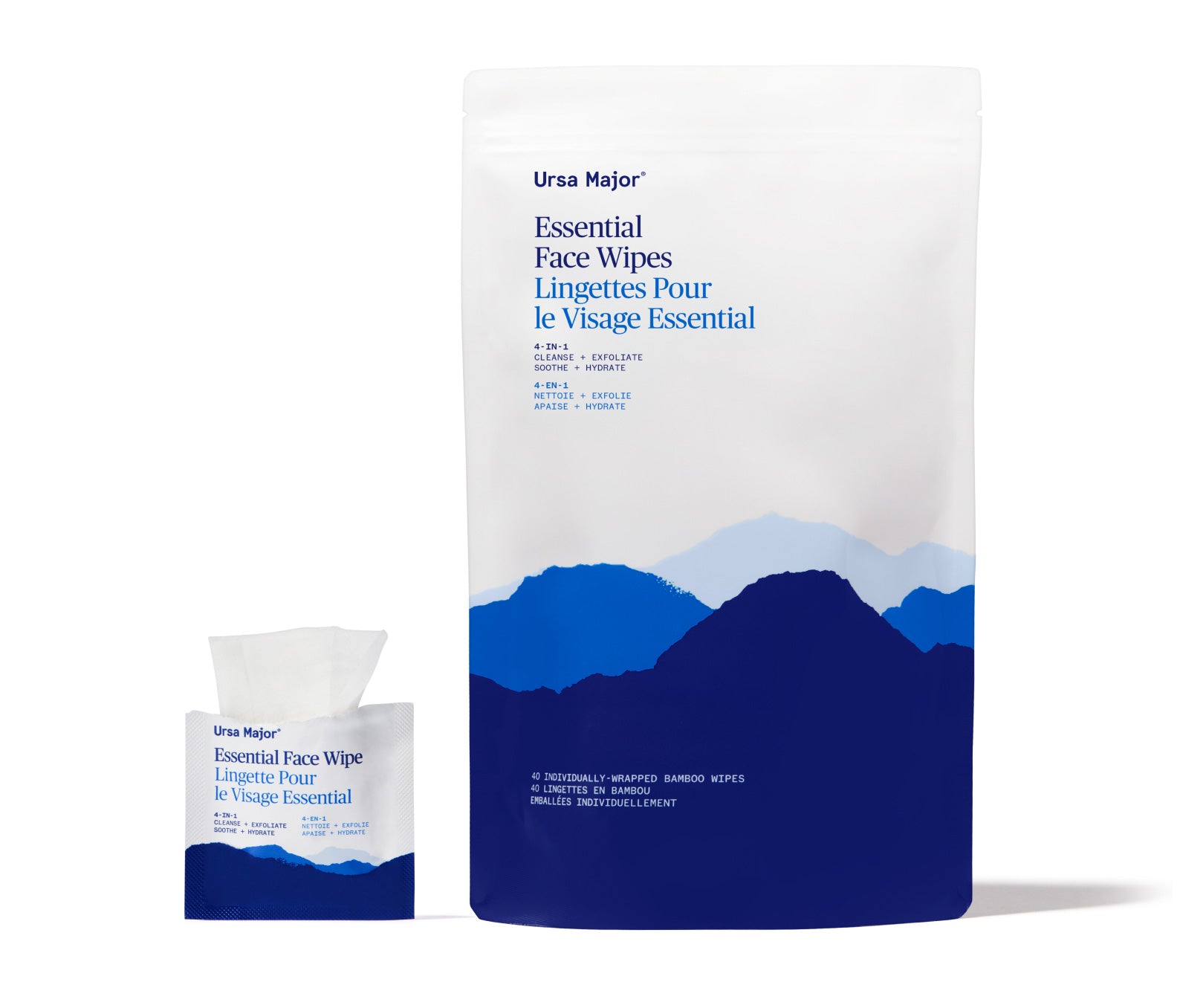 Open packet of Ursa Major Essential Face Wipes, with wipe peeking out of packet, next to a larger pouch with blue mountain design on a white background