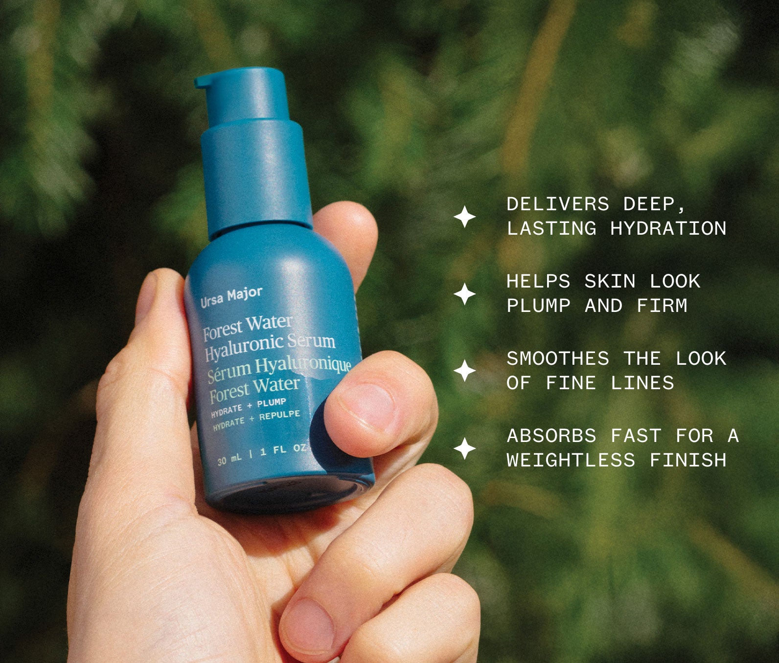 Hand holding a teal bottle of Forest Water Hyaluronic Serum against blurred greenery in the background, with text of product benefits: Delivers deep, lasting hydration; Helps skin look plump and firm; Smooths the look of fine lines; Absorbs fast for a weightless finish