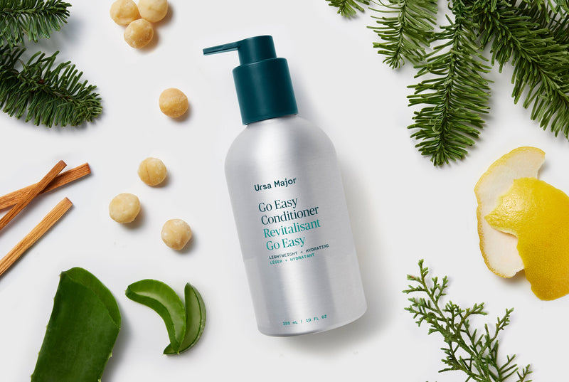 Ursa Major Go Easy Conditioner bottle with natural elements on a white background