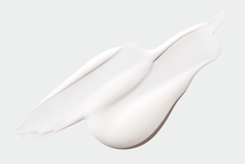 Close-up of a white conditioner smear on a light gray background