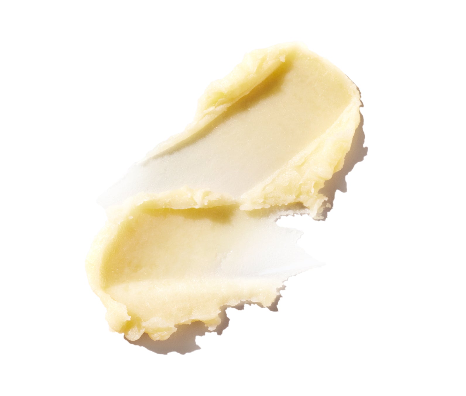 Two swatches of honey-hued, thick lip balm spread on a white background