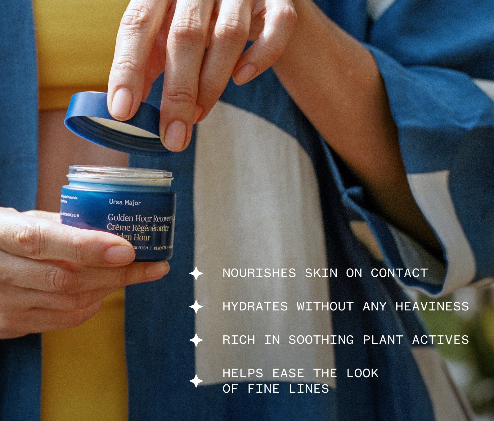 Person holding a jar of Ursa Major Golden Hour Recovery Cream in blurred, sunlit background with product highlights: Nourishes skin on contact; Hydrates without any heaviness; Rich in soothing plant actives; Helps ease the look of fine lines