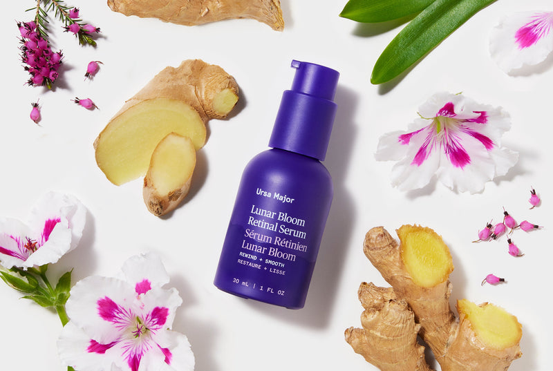 Purple bottle of Lunar Bloom Retinal Serum with natural botanical elements on white background