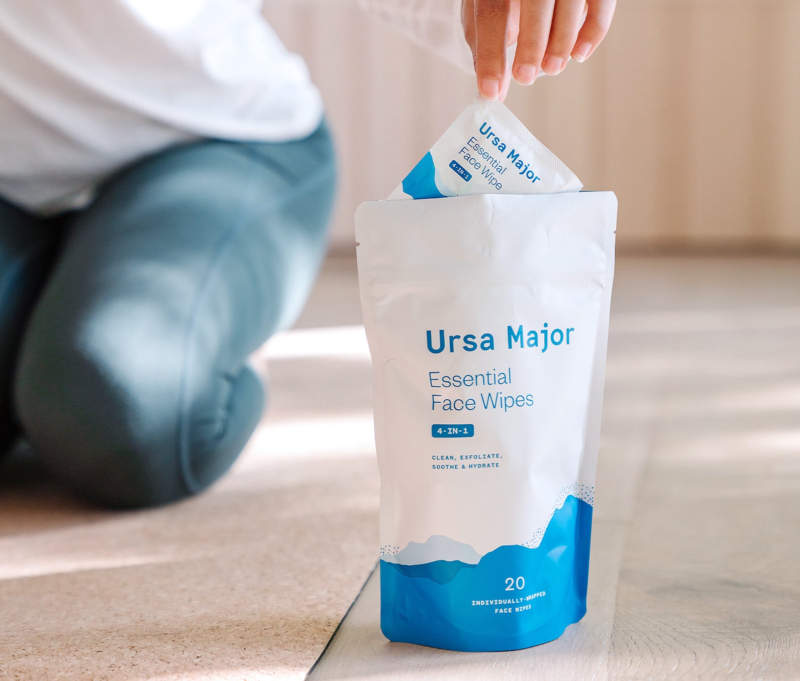 Person pulling pocket-sized Ursa Major face wipes from a package of 20 individually-wrapped wipes.