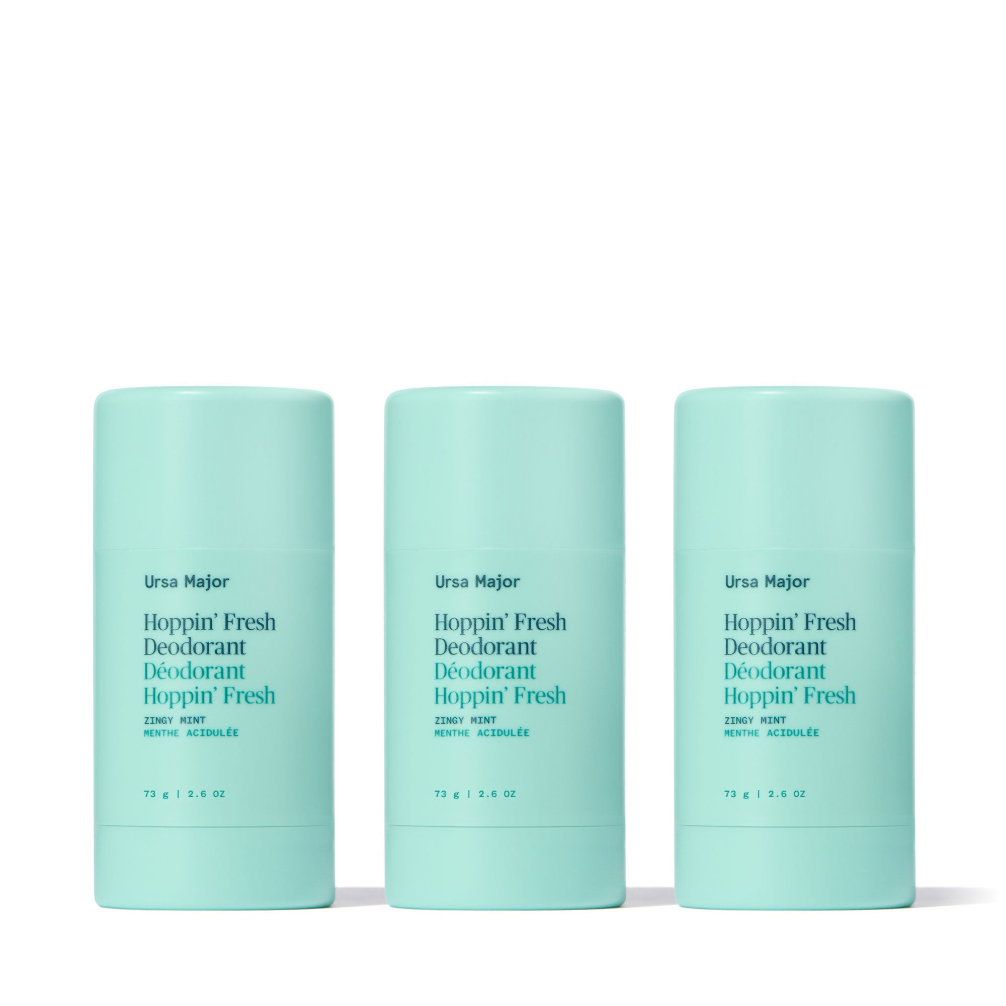 Three mint-green sticks of Ursa Major Hoppin' Fresh Deodorant on a white background