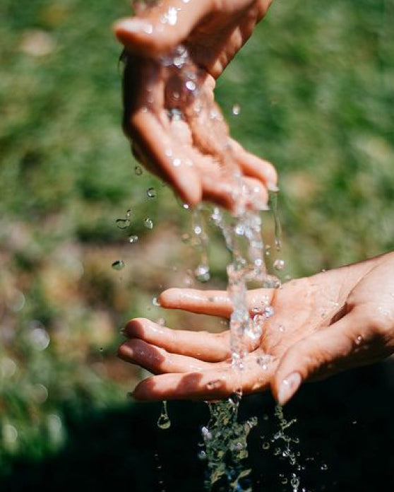 Close-up of two hands with running water flowing over them
