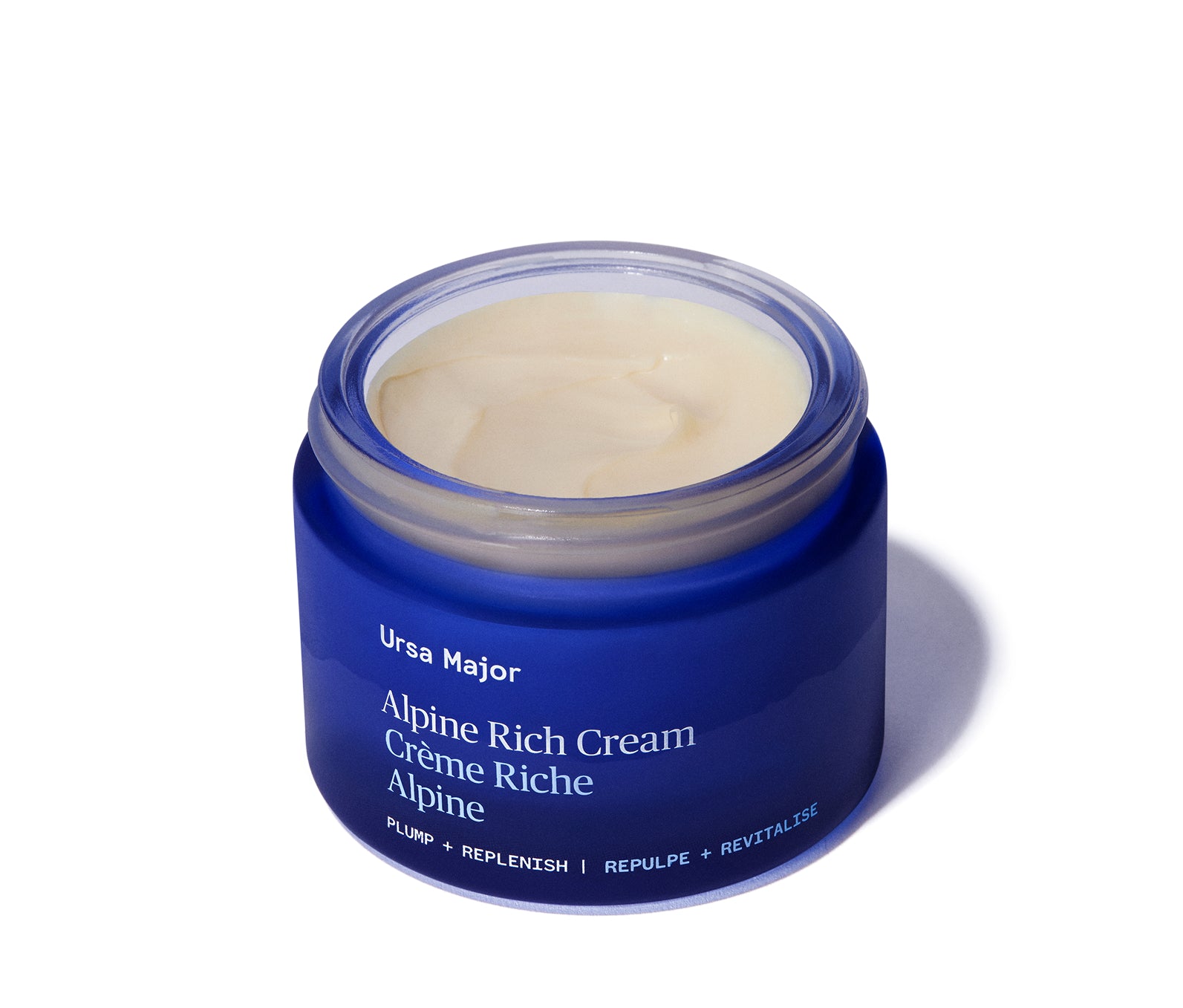 Blue jar of opened Ursa Major Alpine Rich Cream on a white background