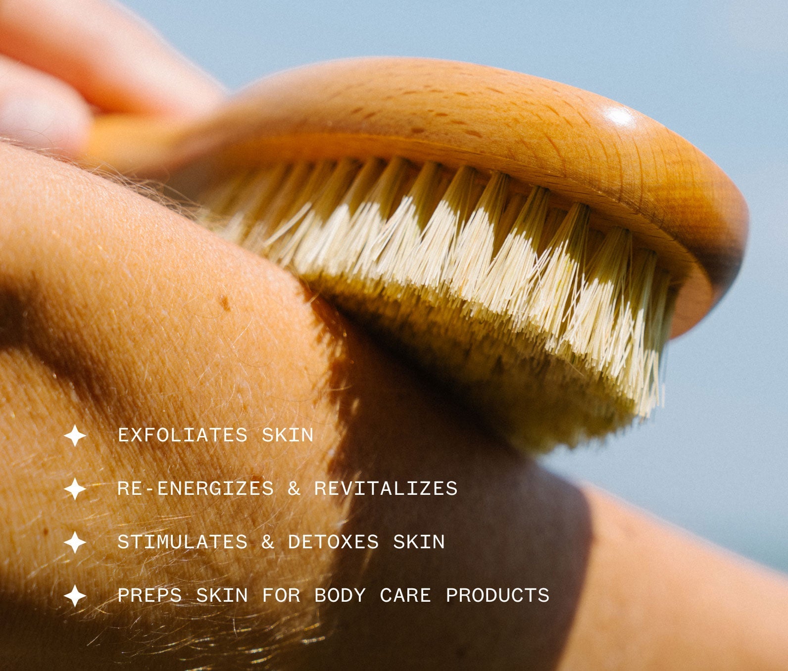 Hand smoothing wooden Dry Brush against skin with text about its benefits, including: Exfoliates skin; Re-energizes and revitalizes; Stimulates and detoxes skin; Preps skin for body care products