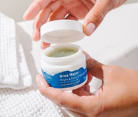 Person opening a jar of Bright & Easy 3-Minute Flash Mask.  Inside the car is a pale green mask consistency.