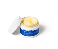 Open jar of Ursa Major Golden Hour Recovery Cream on a white background.  Golden  Hour Recovery Cream is a light-yellow color.