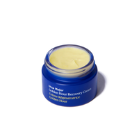 Blue jar of opened Ursa Major Golden Hour Recovery Cream on a white background