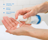 Hand pumping Ursa Major Making Moves Milky Cleanser into the other hand in a white bathroom.  The image has text on it that says this product soothes and hydrates, gently renews, and is an easy-rinsing formula.