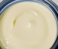 Video of person's hand reaching inside opened jar of Ursa Major Golden Hour Recovery Cream and applying product onto skin