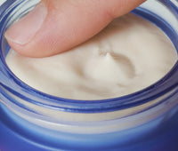 Video of person's finger mixing whipped, creamy contents of opened jar of Ursa Major Alpine Rich Cream, then applying onto their skin.